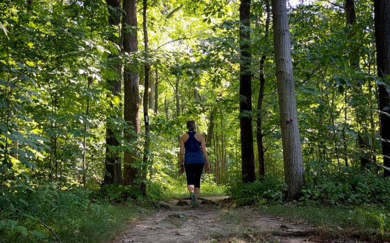 Lindsay Walking Between Trees in the Woodend Conservation Area :: I've Been Bit! Travel Blog