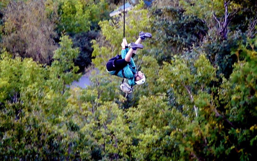 Lindsay rocking the zipline at Scenic Caves Nature Adventure as she hangs upside down from the line :: I've Been Bit! Travel Blog