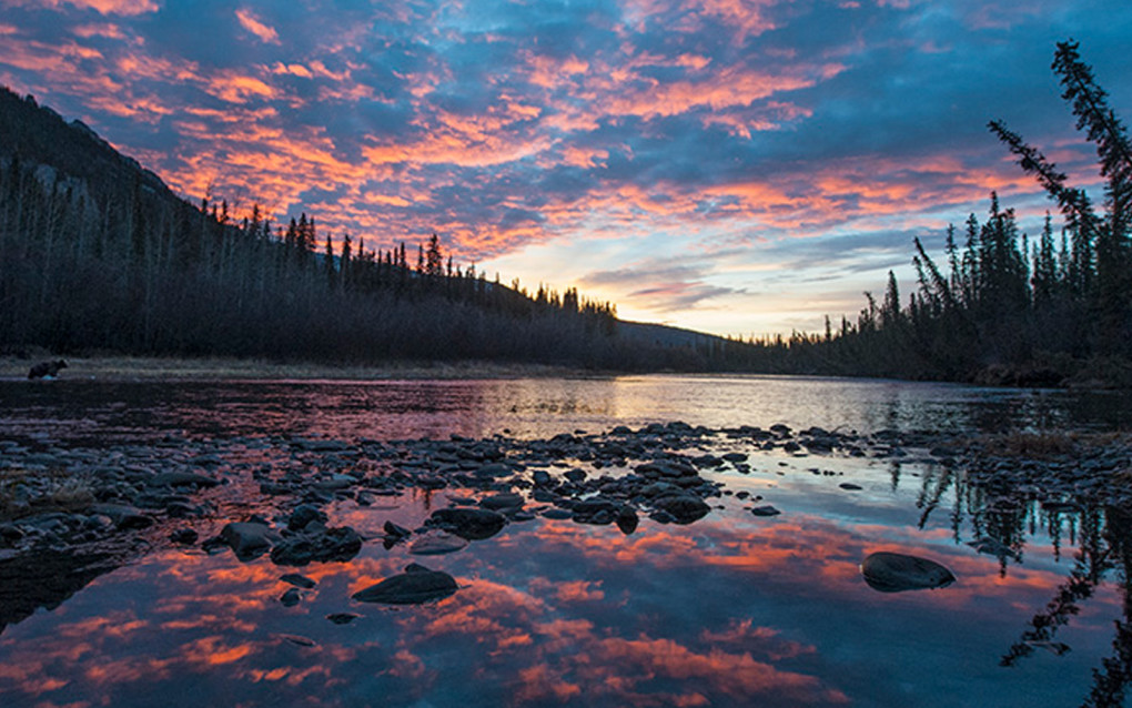 Sunset reflecting off a river in the Yukon, often a bucket list destination for many visiting Canada :: I've Been Bit! Travel Blog