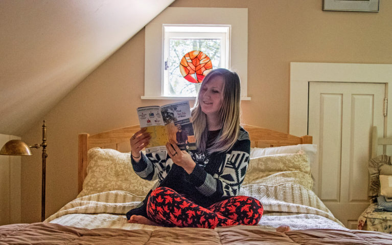 Lindsay Sitting on the Bed in the Haydenville Room Under the Maple Leaf Stained Glass Wearing Her Maple Leaf Tights :: I've Been Bit! Travel Blog