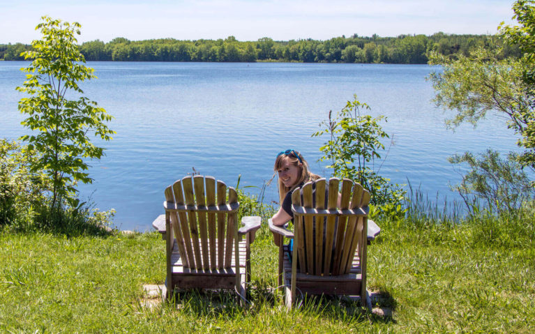 Lindsay Sitting in Muskoka Chairs by the Lake at the Wildwood Conservation Area in Perth County :: I've Been Bit! Travel Blog