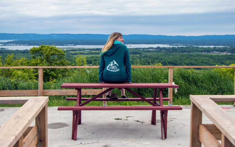 Lindsay Sitting on a Picnic Table at the Macleans Mountain Lookout, Manitoulin Island Ontario :: I've Been Bit! Travel Blog