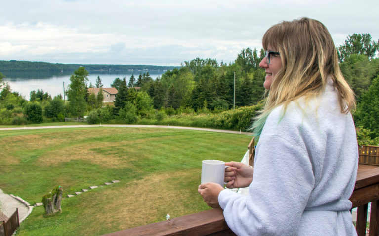 Lindsay Holding a Coffee Looking Over the Balcony at Georgian Bay at the Waterview Resort in Wiarton :: I've Been Bit! Travel Blog
