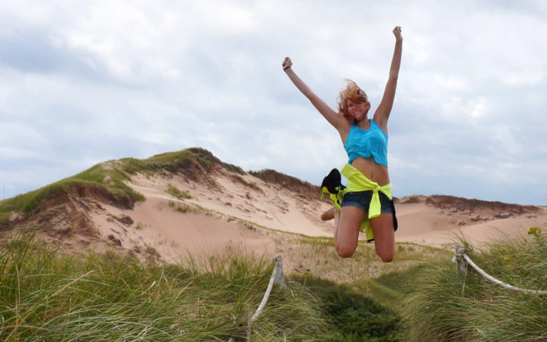 Lindsay Mid-Jump in Front of the Greenwich Sand Dunes in Prince Edward Island :: I've Been Bit! Travel Blog