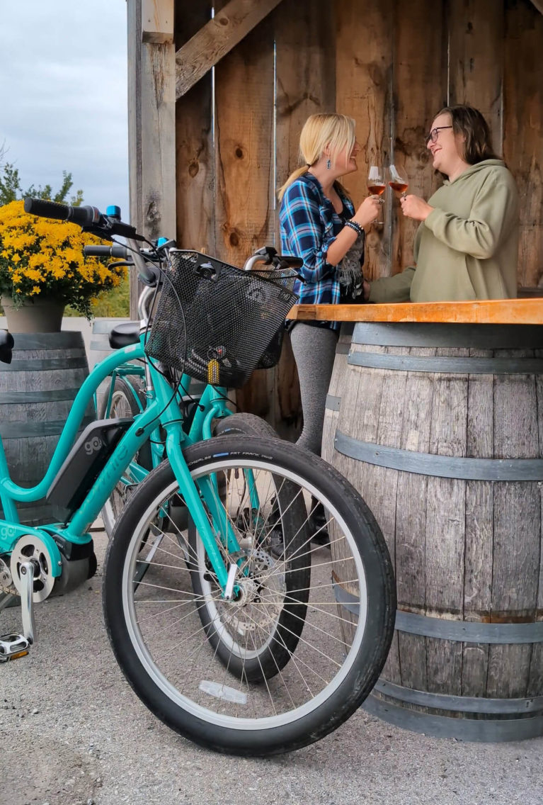 Lindz Cheersing a Glass of Wine at Caroline Cellars with her eBike in the Foreground :: I've Been Bit! Travel Blog