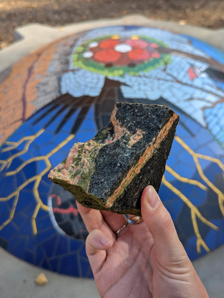 Hand Holding Rock in Front of Indigenous Artwork in Edmonton :: I've Been Bit! Travel Blog