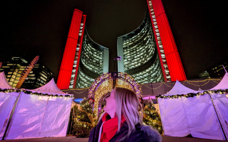 Lindsay Standing In Front of Toronto City Hall at Holiday Fair in the Square at Nathan Phillips Square :: I've Been Bit! Travel Blog