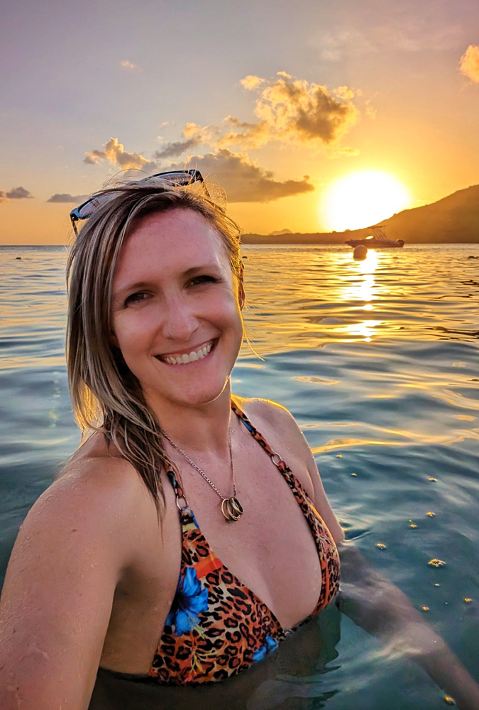 Selfie Photo of Lindz in the Ocean Wearing an Orange, Blue and Black Bikini as the Sun Sets Behind Her :: I've Been Bit! Travel Blog