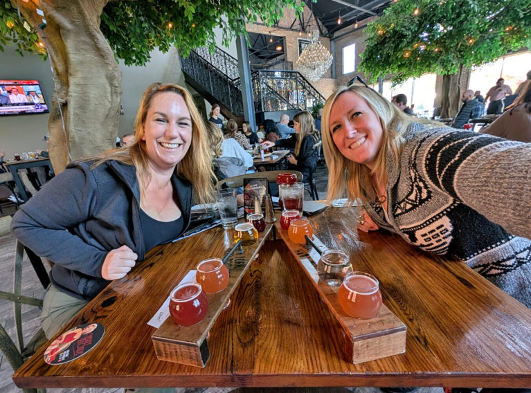 Kat & Lindz Smiling Over a Flight at the New York Beer Project in Victor, NY :: I've Been Bit! Travel Blog